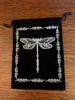 Load image into Gallery viewer, Close-up view of front of bag. Lovely oracle/tarot deck bag with drawstrings for closure. It is black faux velvet with a light blue colored dragonfly embroidered on it with a border around it. This 7&quot;x5&quot; bag can fit most any deck, but is best suited for larger decks (e.g. Medicine Cards). It can also be used to hold and protect large crystals or other precious items. Cost is $7.50

