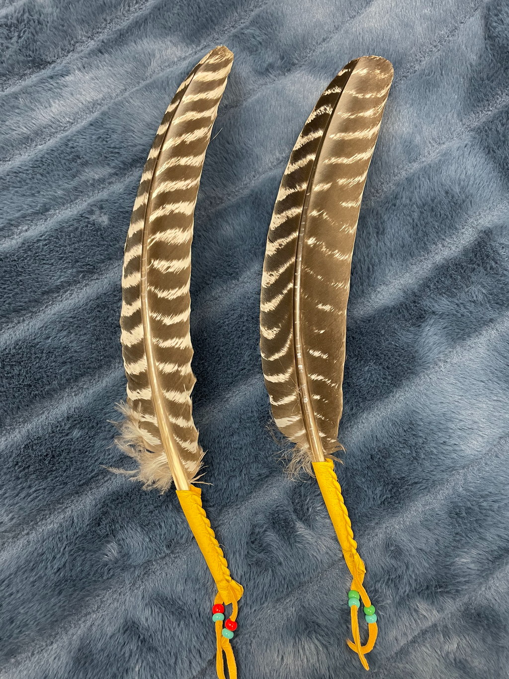 Beautiful feather for smudging, with the shaft wrapped in leather and accented with colorful beads. This is an authentic Native American made product. Use with sage or Palo Santo, etc. You can use it to: *Cleanse, clear & purify your space or environment - home, office, *Cleanse, clear or purify a person & their energy *Promote healing *Promote clarity of mind *Clear out spiritual impurities *Enhance ceremony or ritual. Approximately 13" (or 14" with leather, beaded dangles). Cost is $21.50.