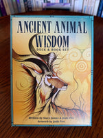 Load image into Gallery viewer, Photo of box front. The Ancient Animal Wisdom Deck and Book Set is beautifully illustrated - very colorful and visually appealing. What I find very special about this deck is that a) all of the animals are ones found in Africa (mostly in Zambia) and b) underneath the English name for the animal, you will find the African name, which I love! I also like the fact that, in the guidebook, they include information about numerology. The set includes 38 cards, a guidebook &amp; box for storage. Cost is $22.95.
