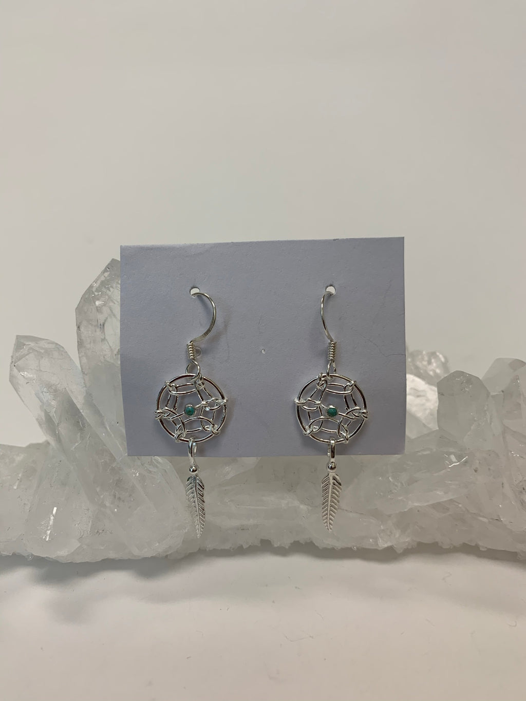 Tiny turquoise gemstones are set in the middle of a round dreamcatcher with a silver feather hanging beneath it. These earrings are very delicate, sweet and lightweight.  They have wires, not posts and are approximately 1½" long.