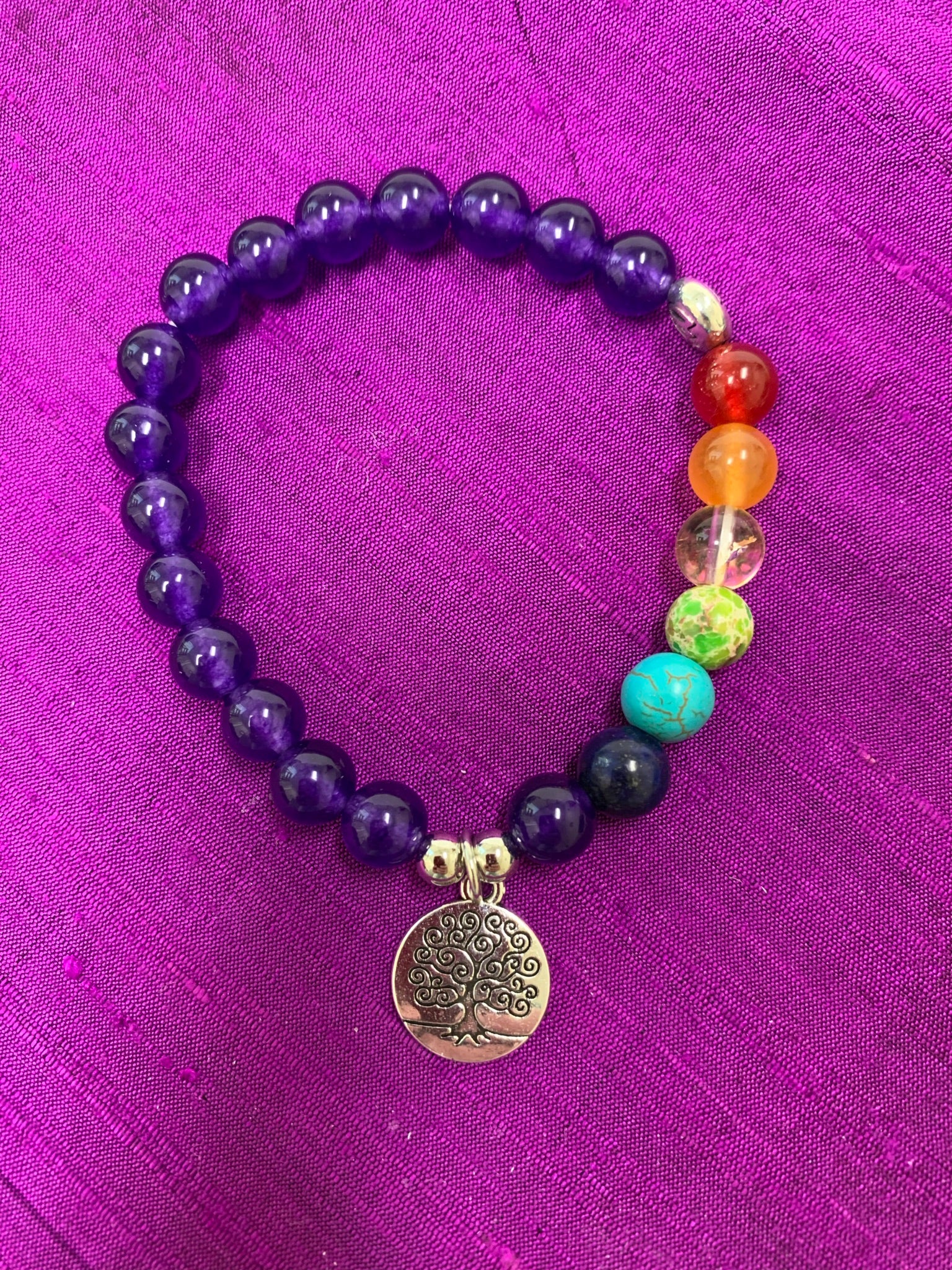 Second close-up of the power bracelet with all amethyst beads except 7 beads to match the chakras. Beads are 8mm. This bracelet also comes with a silver charm that has a tree of life etched in it in black. The beads are genuine but the color has been enhanced. 