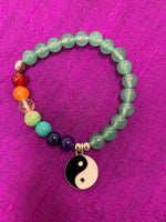 Load image into Gallery viewer, Second close-up view of the aventurine gemstone power bracelet, accented by 7 gemstones, one to match each of the 7 chakras and a black and white yin yang charm as well as three additional silver colored beads (The silver base of the charm and the silver colored beads are not sterling silver). The gemstone beads are 8mm.
