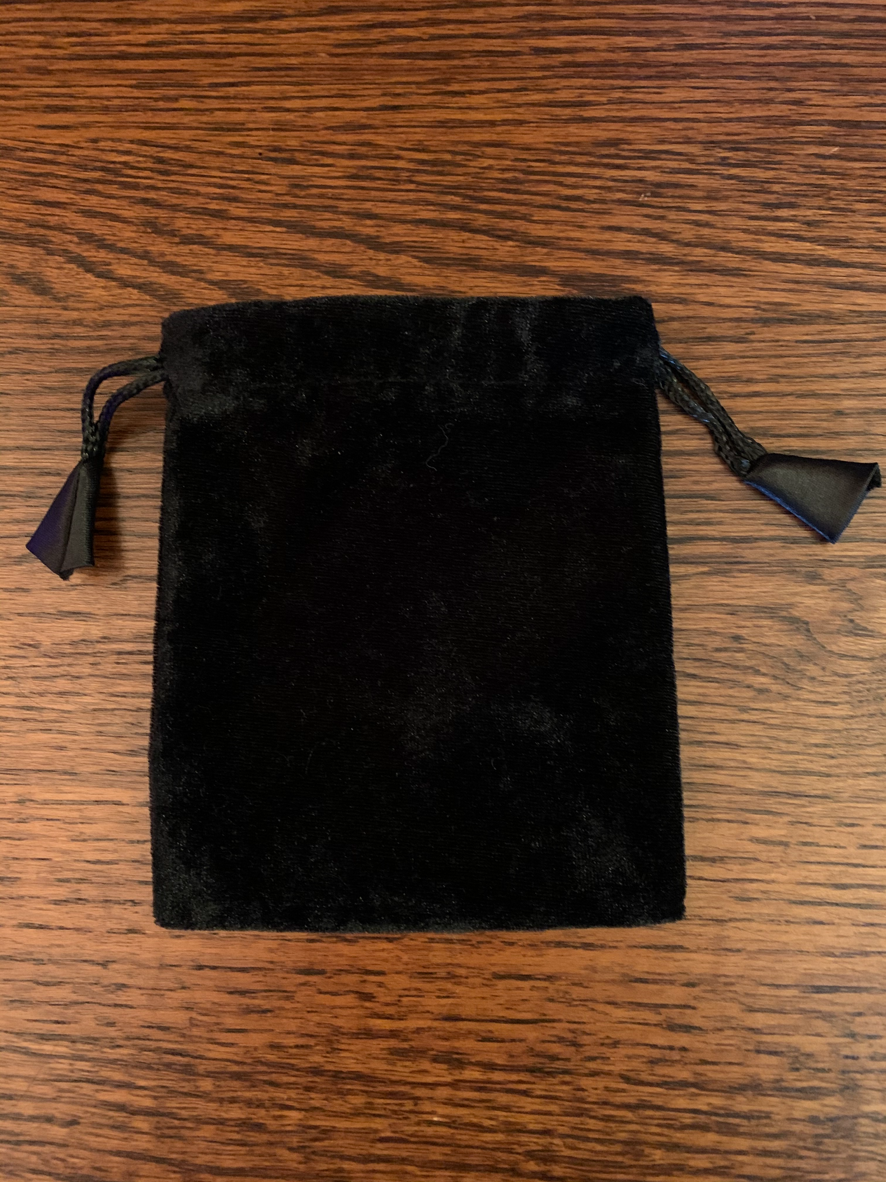 Close-up view. Plain black Velvet tarot/oracle deck bag (no design) to store cards. Drawstrings for closure. Size: 5.75"x4.75". Holds small decks only (e.g. Shamanic Healing Oracle Cards, Original Angel Cards, etc.). Can also be used to store & protect small to medium size crystals, gemstones or other precious items.  Cost is $4.99