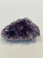 Load image into Gallery viewer, Different angle. Glittering amethyst geode piece is lovely to use for its properties and also as a lovely piece for your altar, bookshelf or nightstand. Amethyst, one of the most spiritual gemstones, heals, cleanses &amp; calms, allowing you to reach meditative &amp; higher consciousness levels more easily. It also helps to dispel negative emotional states (and so much more). Cost is $5.98
