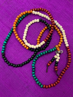 Load image into Gallery viewer, Close-up view. Prayer beads/mala necklace strung with 216 beads allowing you to do 2 repetitions of the traditional 108 for chanting mantras during meditation. Beads are all wooden and in a colorful array on the necklace (green, black, tan, orange and brown beads). Twelve of the beads dangle from the necklace in two short, separate strands with a small silver colored accent above them. Silver colored accent is not sterling silver.
