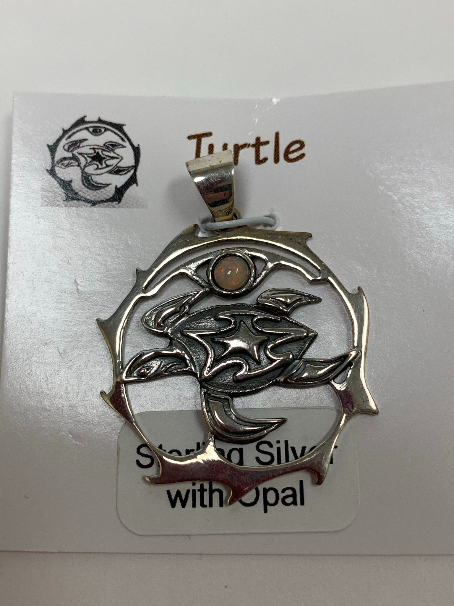 Close-up view. Sterling silver spirit animal, sea turtle, pendant, accented with an opal gemstone. Sea turtle is inside of a stylized, sterling silver, open circle with the opal above it. Wear your spirit animal so you can take its energy everywhere you go! Pendant only, necklace chain not included.