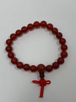 Load image into Gallery viewer, Close-up view. Carnelian power bracelet accented with red Chinese tassel knot. Beads are 8 mm. Carnelian promotes courage, creativity, vitality and dispels emotional negativity.
