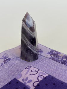 Alternate view. Chevron amethyst tower with the coolest banding for your altar, for healing or as décor for any room in your home or office. Amethyst, one of the most spiritual gemstones, heals, cleanses & calms, allowing you to reach meditative & higher consciousness levels more easily. It also helps to dispel negative emotional states and more. Chevron amethyst is a combination of amethyst and white quartz and when you add the quartz you get additional qualities. Approx. 2¼" long. Cost is $13.20.