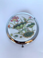 Load image into Gallery viewer, Great little compact mirror for purse or vanity. It is hinged with 2 mirrors.Aand the lotus adds a beautiful and spiritual touch. It is functional and also elegant. I keep mine out on my bathroom counter because it is so pretty to look at. The lotus flower is a sacred symbol reminding us that we all must push through the mud to get to the light. It stands for purity, strength and enlightenment.  It is approximately 2¾&quot; across. Great gift, great price - $5.00.

