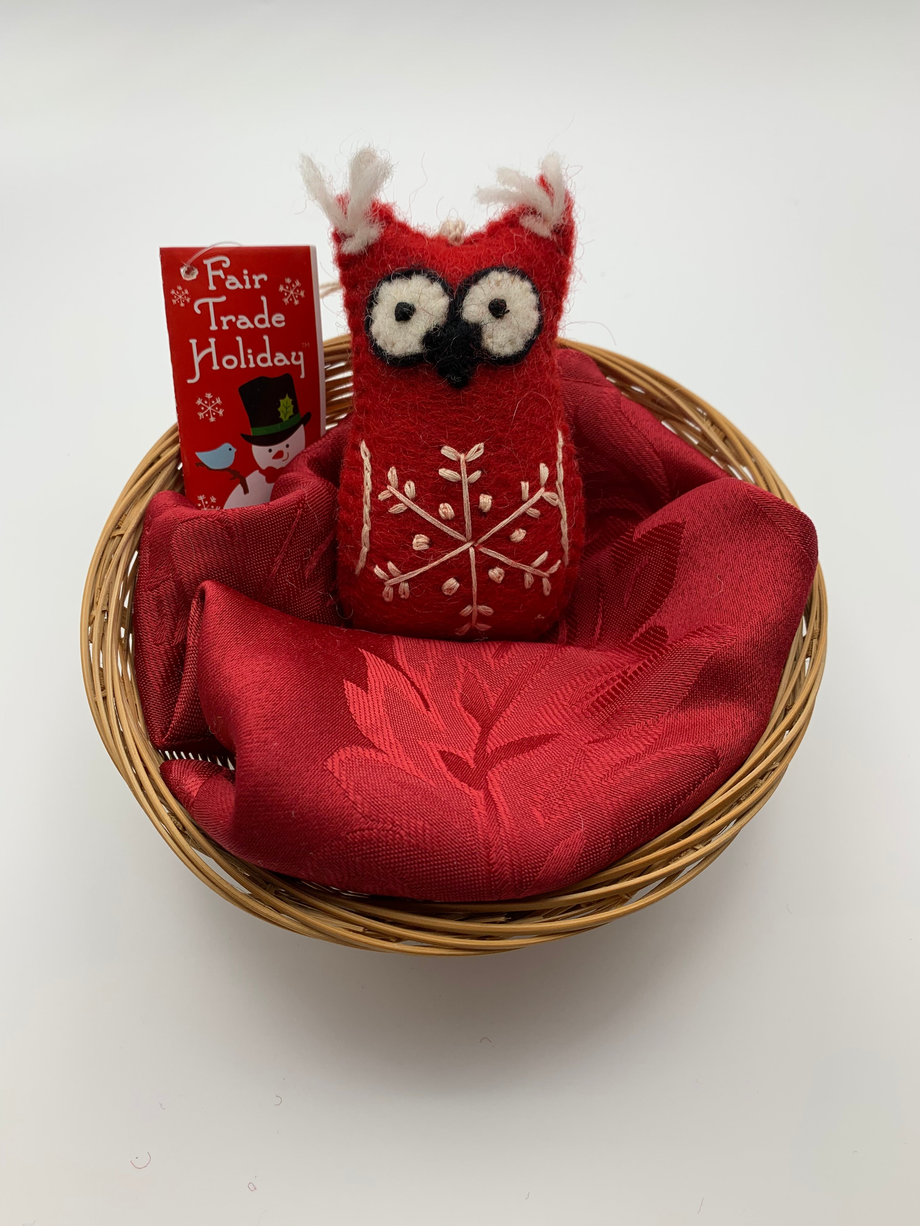 This is  a red owl Christmas ornament that is handcrafted (fair trade) and made of 100% hand-felted natural wool. It is red with black and white accents and tufts of white hair on its ears & has a 'signature' (white) snowflake on its belly. Approximately 4"x2.5".  Comes with a fair trade holiday "to/from" tag to use if giving this as a gift.