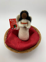 Load image into Gallery viewer, This is an angel of color (black) Christmas ornament that is handcrafted (fair trade) and made of 100% natural wool. She wears a white dress accented with red and gold beading on empire waist, has a gold beaded halo, black face and hair and bendable arms.  Approximately 5&quot;x2.5&quot;.  She comes with a fair trade holiday &quot;to/from&quot; tag to use if giving this as a gift.     

