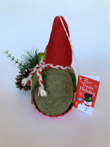 This is a back view of the sledding gnome Christmas ornament that is handcrafted (fair trade) and made of 100% natural wood. The sled is handmade using paper that is hardened and feels almost like thin wood. He wears a green top, brownish-gray pants, a pointed red hat, which covers his eyes, a round tan nose and sits on a round, red sled that has gold colored sled handles on either side. Approximately 6.5"x3.75"x3.5". He comes with a fair trade holiday "to/from" tag to use if giving this as a gift.