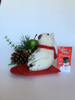 Load image into Gallery viewer, This is a side view of the sledding polar bear Christmas Ornament that is handcrafted (fair trade). The polar bear is made of 100% natural wool and the sled is handmade with paper that is hardened and feels somewhat like very thin wood and it is red. The bear is off-white with a tan belly, brownish-gray muzzle, black accents (paws, nose, etc.) and is wearing a red winter scarf. It is approximately 4.75&quot;x3.5&quot;x2.5&quot; It comes with a fair trade holiday &quot;to/from&quot; tag to use if giving this as a gift.
