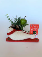 Load image into Gallery viewer, This is a back view of the snowboarding seal Christmas ornament that is handcrafted (fair trade) using 100% natural wool. The snowboard is handmade using paper that is hardened and feels almost like thin wood. It is off-white with black accents (eyes, nose, whiskers etc.), wears a red winter scarf and is lying on a red snowboard with green accents. Approximately 5.5&quot;x2&quot;x1.75&quot;. It comes with a fair trade holiday &quot;to/from&quot; tag to use if giving this as a gift.
