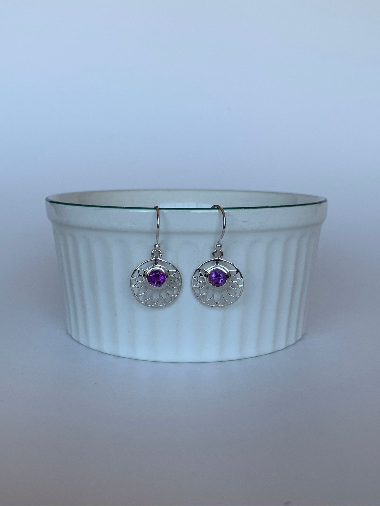 Round amethyst gemstones are set into a delicate, open, sterling silver lotus pattern.  These earrings are lightweight, have wires, not posts and are approximately 1½" long.