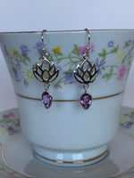 Load image into Gallery viewer, Close up of sterling silver earrings with earring wires, not posts. An amethyst (reverse teardrop) hangs from an open sterling silver lotus design. Earrings are lightweight and are approximately 1½&quot; long.
