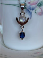 Load image into Gallery viewer, Close up View - Lovely Sterling silver pendant has upturned crescent moon with small round moonstone sitting on its curve with a blue kyanite stone hanging below the moon. It is lightweight and approximately 1¼&quot; long. Necklace chain in for display only and does not come with the pendant.

