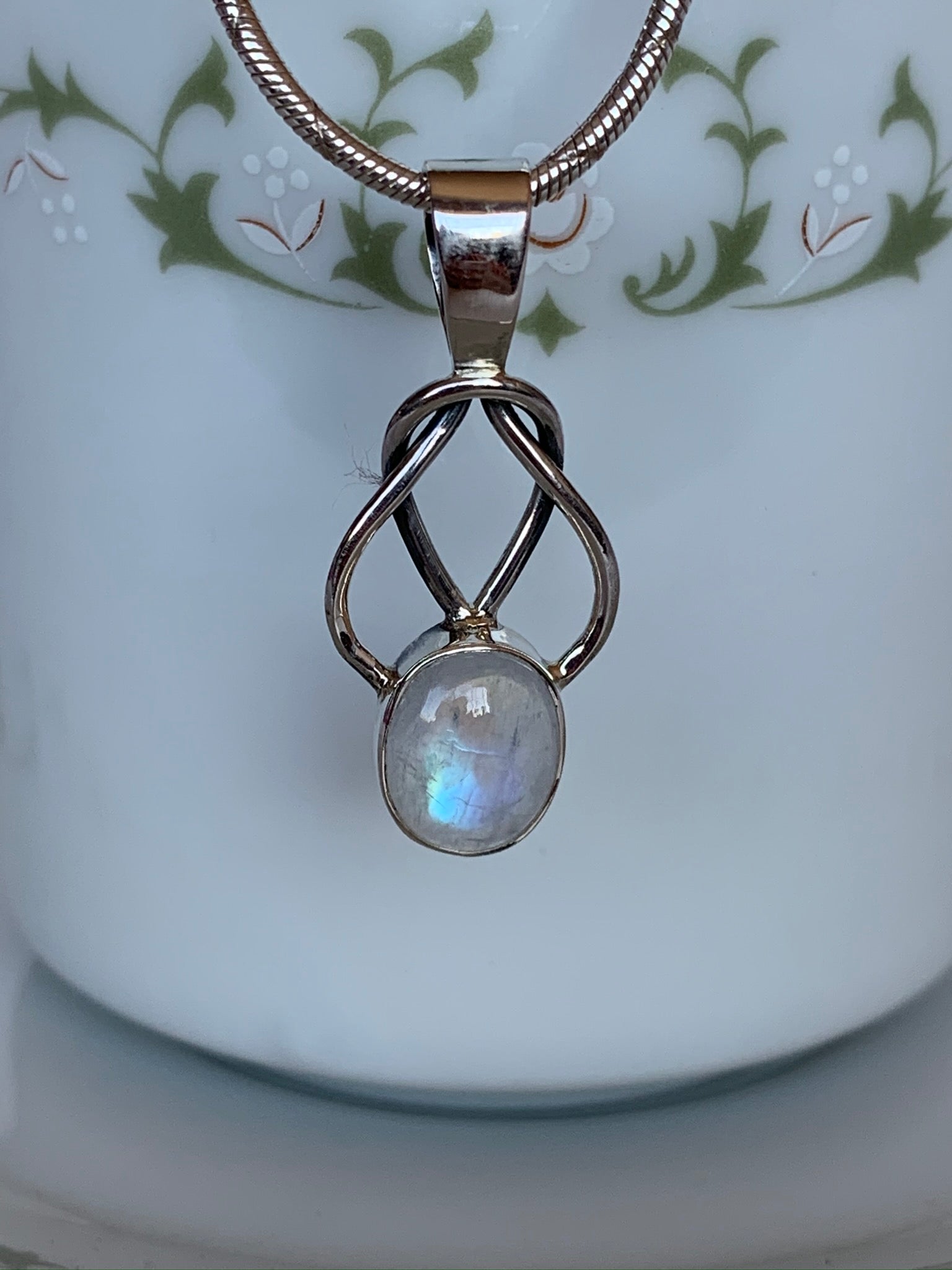 Close-up view. This is a sterling silver love knot pendant (2 strands) with a beautiful moonstone at the bottom. The necklace chain is not included. Pendant is lightweight and is approximately 1¾" long. Necklace chain not included.
