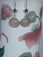 Load image into Gallery viewer, Close-up view. Good size, round rose quartz gemstones, set in sterling silver, dangle from a sterling silver star. These have wires, not posts, are lightweight and are approximately 1½&quot; long.

