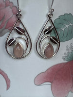 Load image into Gallery viewer, Close-up view, teardrop pink Chalcedony set in sterling silver at the bottom of an open sterling silver teardrop shape with sterling silver &quot;swaying&quot; leaves above. Wires, not posts. These earrings are lightweight and approximately 1¼&quot; long.
