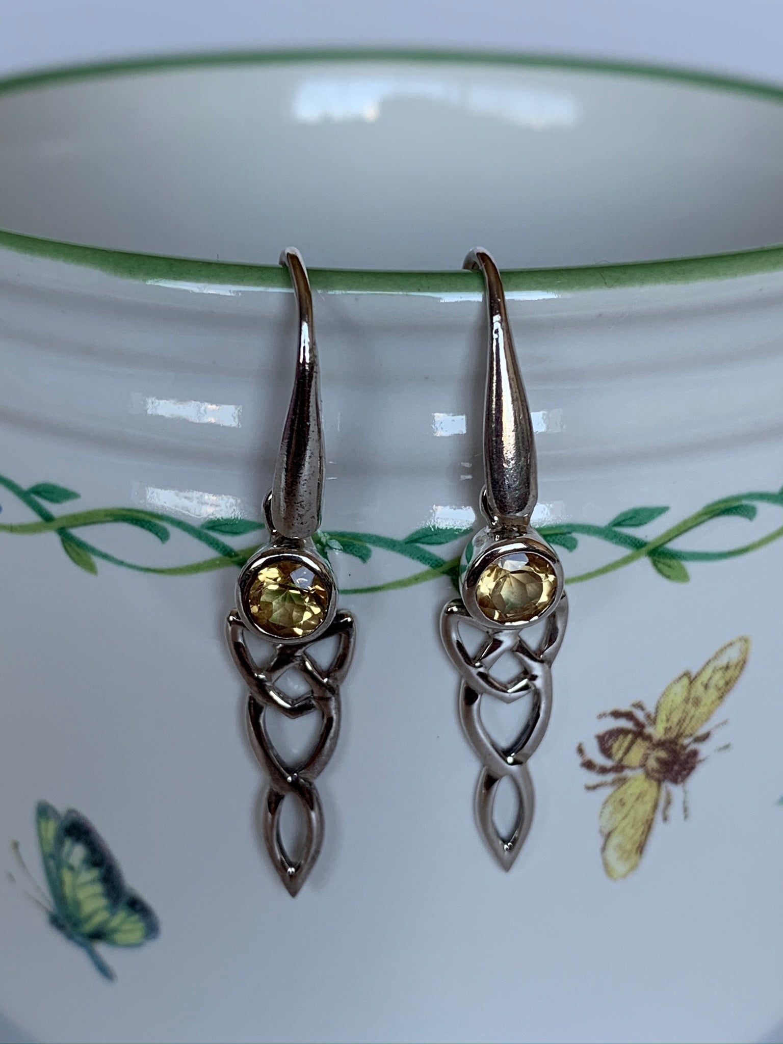Close-up view. Round faceted citrine gemstone set in sterling silver with elongated sterling silver Celtic knot below. Wires, not posts and the wires are a bit thicker than usual. Approximately 1½" long.