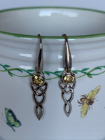 Load image into Gallery viewer, Close-up view. Round faceted citrine gemstone set in sterling silver with elongated sterling silver Celtic knot below. Wires, not posts and the wires are a bit thicker than usual. Approximately 1½&quot; long.
