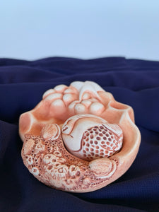 This lovely sacred art sculpture with removable mermaid is entitled The Ocean's Gift.  Water is life to all of us and is sacred in its own right. The cotton at the bottom is for collecting drops of water from sacred sites or ceremonies. From the cotton it wicks up into the sculpture and holds the energy of the site or ceremony. Approximately 3" across. Clay impressions for this sculpture were taken from barnacles and shells living on a fourteen million year old lava flow in Oregon.