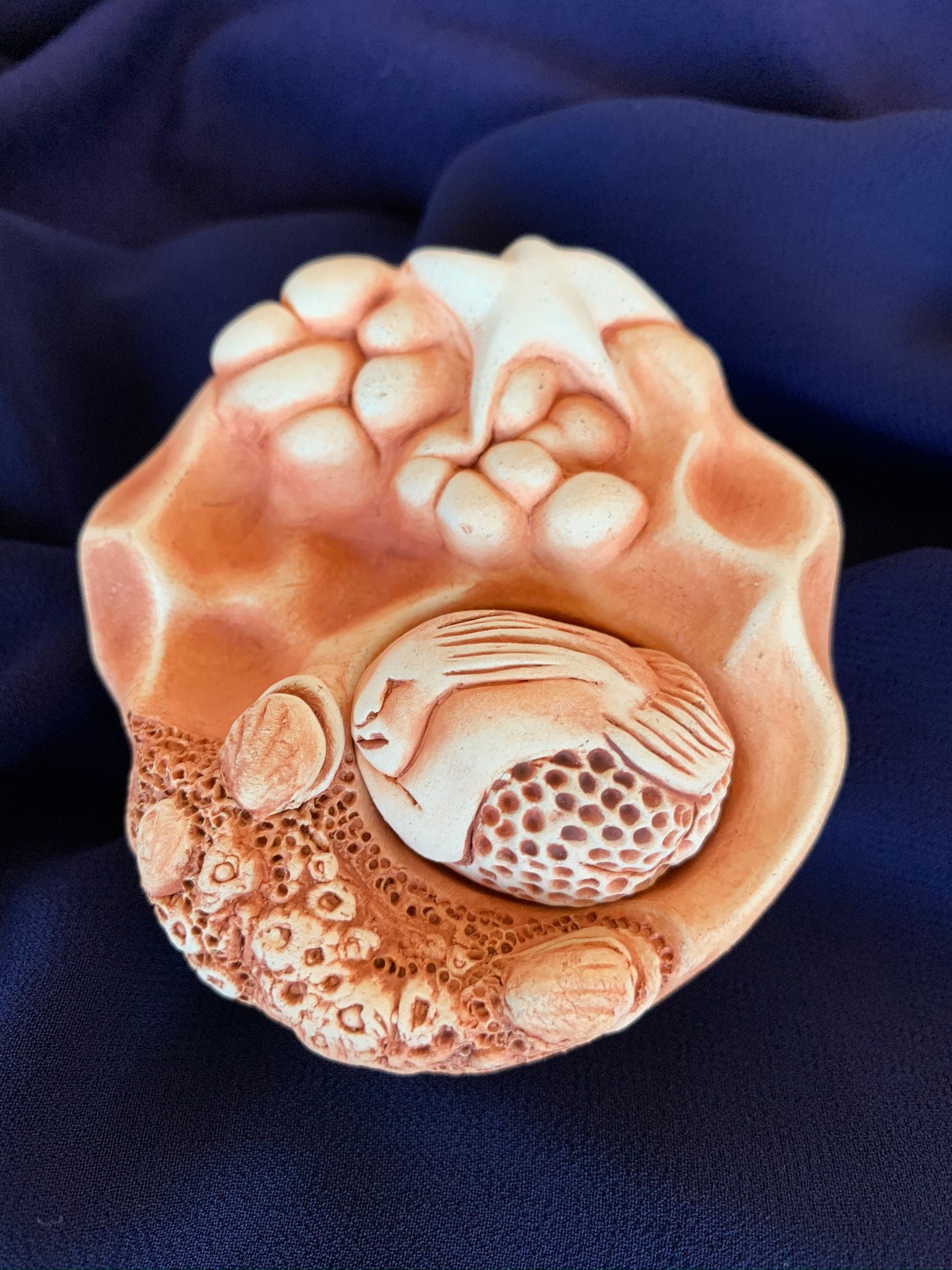 This lovely sacred art sculpture with removable mermaid is entitled The Ocean's Gift.  Water is life to all of us and is sacred in its own right. The cotton at the bottom is for collecting drops of water from sacred sites or ceremonies. From the cotton it wicks up into the sculpture and holds the energy of the site or ceremony. Approximately 3" across. Clay impressions for this sculpture were taken from barnacles and shells living on a fourteen million year old lava flow in Oregon.