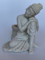 Load image into Gallery viewer, Close-up front view  of the beautiful sandstone Buddha candle holder - a welcome addition to your altar, mediation space or simply to add to the décor of your home. Add a votive candle to increase the ambiance or to use as a focus during spiritual practice. Buddha is revered around the world and his teachings and actions have shown us the beauty, wonder and power of enlightenment. The term Buddha refers to the Awakened One. Size is approximately 3¼&quot; tall. It is cast in sandstone and natural resin.
