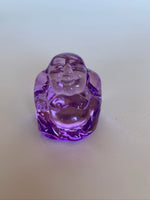 Load image into Gallery viewer, Close up View of one of the Set of 5 Little glass Buddha statues in fun colors! Buy the set, give some away (or keep them all for yourself ;). Colors include purple, pink, amber, yellow/gold and blue. Buddha is revered around the world and his teachings and actions have shown us the beauty, wonder and power of enlightenment. The term Buddha refers to Awakened One. Add one or more to your altar, meditation space or carry in your pocket or purse as a reminder of your spiritual journey.
