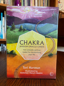Front of deck box. Chakra Wisdom Oracle Cards are a divination system that Tori Hartman came up with after a near death experience. Angels revealed the mystical fairy tales depicted on each card. Each card also represents one of the 7 major chakras. This set includes 49 oracle cards, a guidebook (which includes a "personal inquiry and focused meditation for each of the 49 cards) and a box for storing them. Tori Hartman is a "popular American psychic. Price is $19.95.
