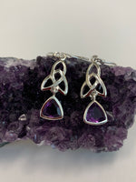 Load image into Gallery viewer, Trilliant cut (triangular) faceted amethyst gemstones outlined in sterling silver, dangle from an elongated Celtic trinity knot, or triquetra. These earrings are lightweight, have wires, not posts and are approximately 1½&quot; long.
