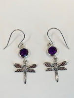 Load image into Gallery viewer, Close-up View. Round amethyst gemstones set above sterling silver dragonflies, which dangle below. These earrings are lightweight, have wires, not posts and are approximately 1¼&quot; long.
