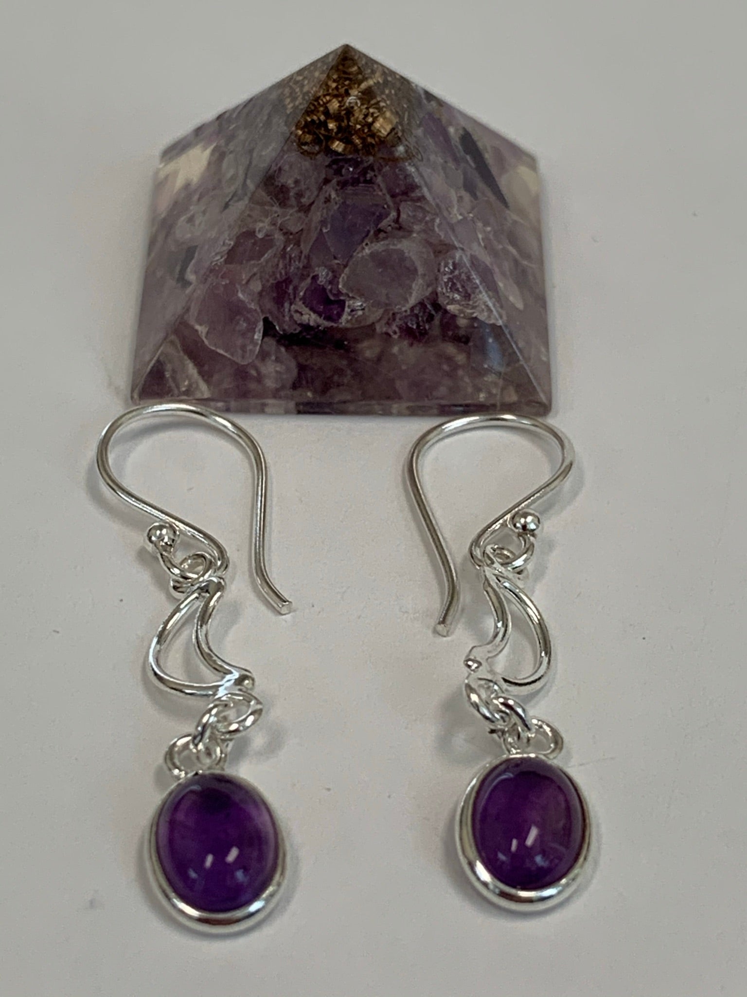 Close-up View. Little round amethyst gemstones (cabs, not faceted) dangle below two small open crescent moons. These earrings are lightweight, have wires, not posts and are approximately 1½" long.