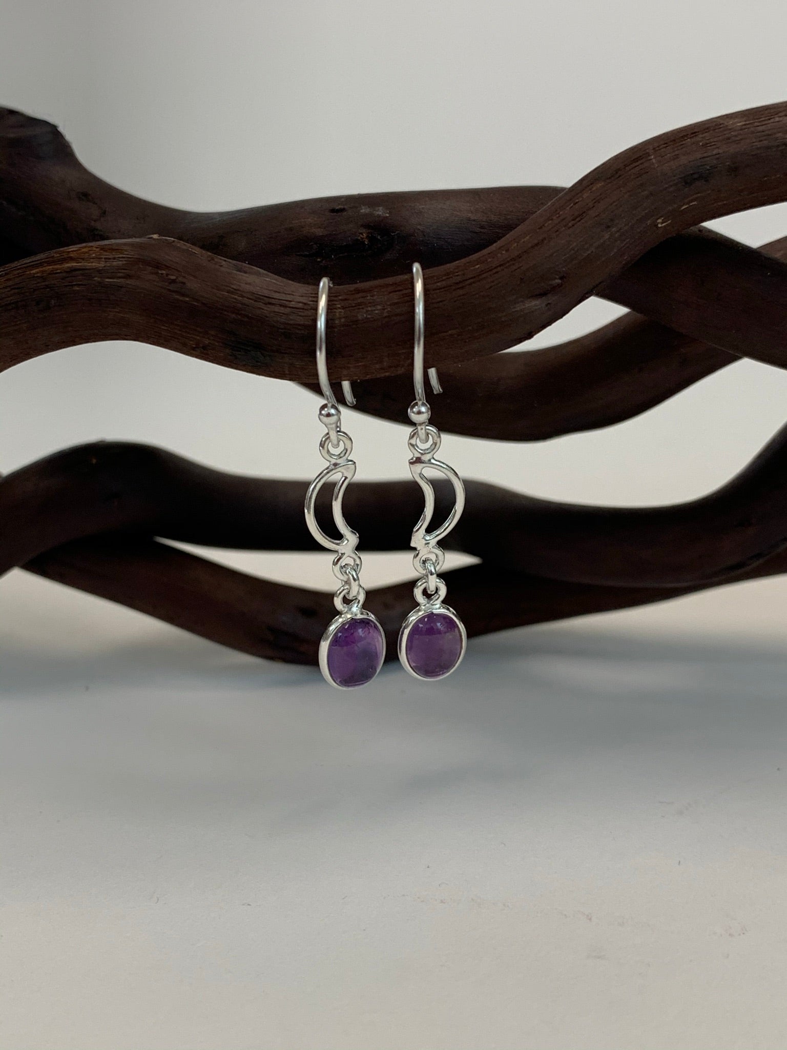 Little round amethyst gemstones (cabs, not faceted) dangle below two small open crescent moons. These earrings are lightweight, have wires, not posts and are approximately 1½" long.