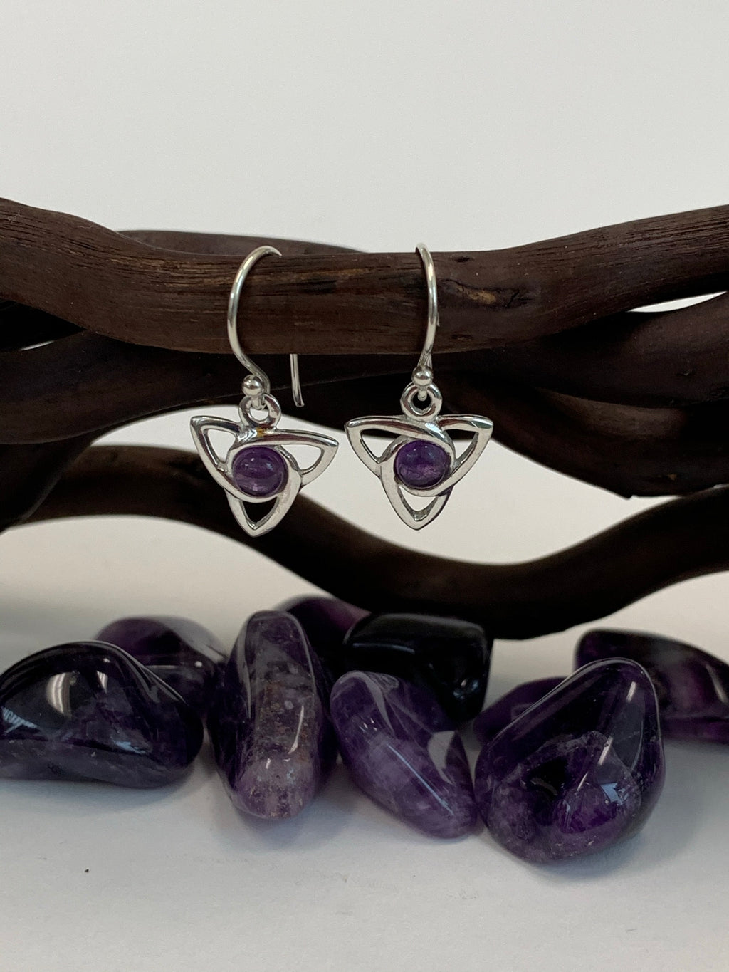 Round amethyst gemstones (cabs, not faceted) sit in the middle of a sterling silver Celtic trinity knot (or triquetra). These earrings are lightweight, have wires, not posts and are approximately 1¼" long.