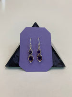 Load image into Gallery viewer, Two amethyst gemstones are set into each of the sterling silver earrings in a &quot;twister&quot; setting (like a stylized figure 8), one in the top part of the eight and one in the bottom. These earrings are lightweight, have wires, not posts and are approximately 1¼&quot; long. 
