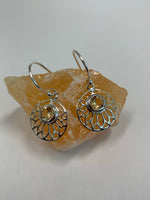 Load image into Gallery viewer, Another Close-up view. Round, faceted citrine gemstones are set at the top of an open sterling silver lotus flower, which itself is set in a circle of sterling silver. These earrings are lightweight, have wires, not posts and are approximately 1½&quot; long.
