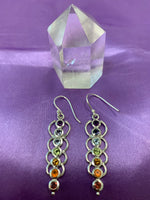 Load image into Gallery viewer, Chakra energy link earrings. Small faceted stones that represent each of the chakras: amethyst/crown, iolite/third eye, blue topaz/throat, peridot/heart, citrine/solar plexus, carnelian/sacral (or naval), garnet/root (or base). These stones are set in links or loops of sterling silver, two per loop or link go straight down the middle.  Wires not posts and approximately 1¾&quot;.
