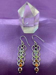 Chakra energy link earrings. Small faceted stones that represent each of the chakras: amethyst/crown, iolite/third eye, blue topaz/throat, peridot/heart, citrine/solar plexus, carnelian/sacral (or naval), garnet/root (or base). These stones are set in links or loops of sterling silver, two per loop or link go straight down the middle.  Wires not posts and approximately 1¾".