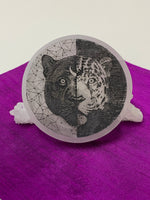 Load image into Gallery viewer, Jaguar and black jaguar etched onto a smooth, polished selenite charging plate that can be used for charging crystals &amp; jewelry.  Selenite ranges from translucent to milky white in color. The etched jaguar is the head only and half of it is a black Jaguar on a white background and the other half is a white, spotted jaguar on a black background. Average weight is 9.1 oz., and average size is approx. 4&quot; in diameter and approx. ½&quot; thick. This selenite is ethically sourced and workers are paid living wages.
