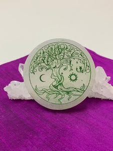 Celtic Tree of Life etched on smooth, white selenite plate, used for charging your crystals and jewelry (or just for décor). The etched tree is painted green and the selenite plate ranges from translucent to milky white in color. Weight & size vary, but average weight is 4.9 oz, size is approximately 3" in diameter and approximately ½" thick. The selenite is ethically sourced and workers are paid living wages.