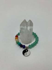 Aventurine gemstone power bracelet, accented by 7 gemstones, one to match each of the 7 chakras and a black and white yin yang charm as well as three additional silver colored beads (The silver base of the charm and the silver colored beads are not sterling silver). The gemstone beads are 8mm.