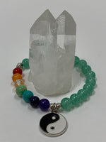 Load image into Gallery viewer, Close-up view of the aventurine gemstone power bracelet, accented by 7 gemstones, one to match each of the 7 chakras and a black and white yin yang charm as well as three additional silver colored beads (The silver base of the charm and the silver colored beads are not sterling silver). The gemstone beads are 8mm.
