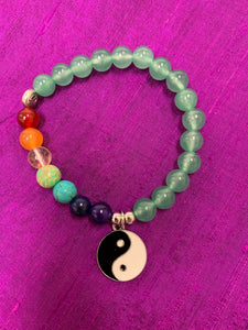 Second close-up view of the aventurine gemstone power bracelet, accented by 7 gemstones, one to match each of the 7 chakras and a black and white yin yang charm as well as three additional silver colored beads (The silver base of the charm and the silver colored beads are not sterling silver). The gemstone beads are 8mm.