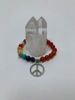 Load image into Gallery viewer, Carnelian gemstone power bracelet, accented by 7 different gemstones, representing the 7 chakras and a silver-colored peace sign charm and 3 additional silver-colored beads (2 of which are plain and one has a lotus on it). These additional silver colored beads are not sterling silver. 
