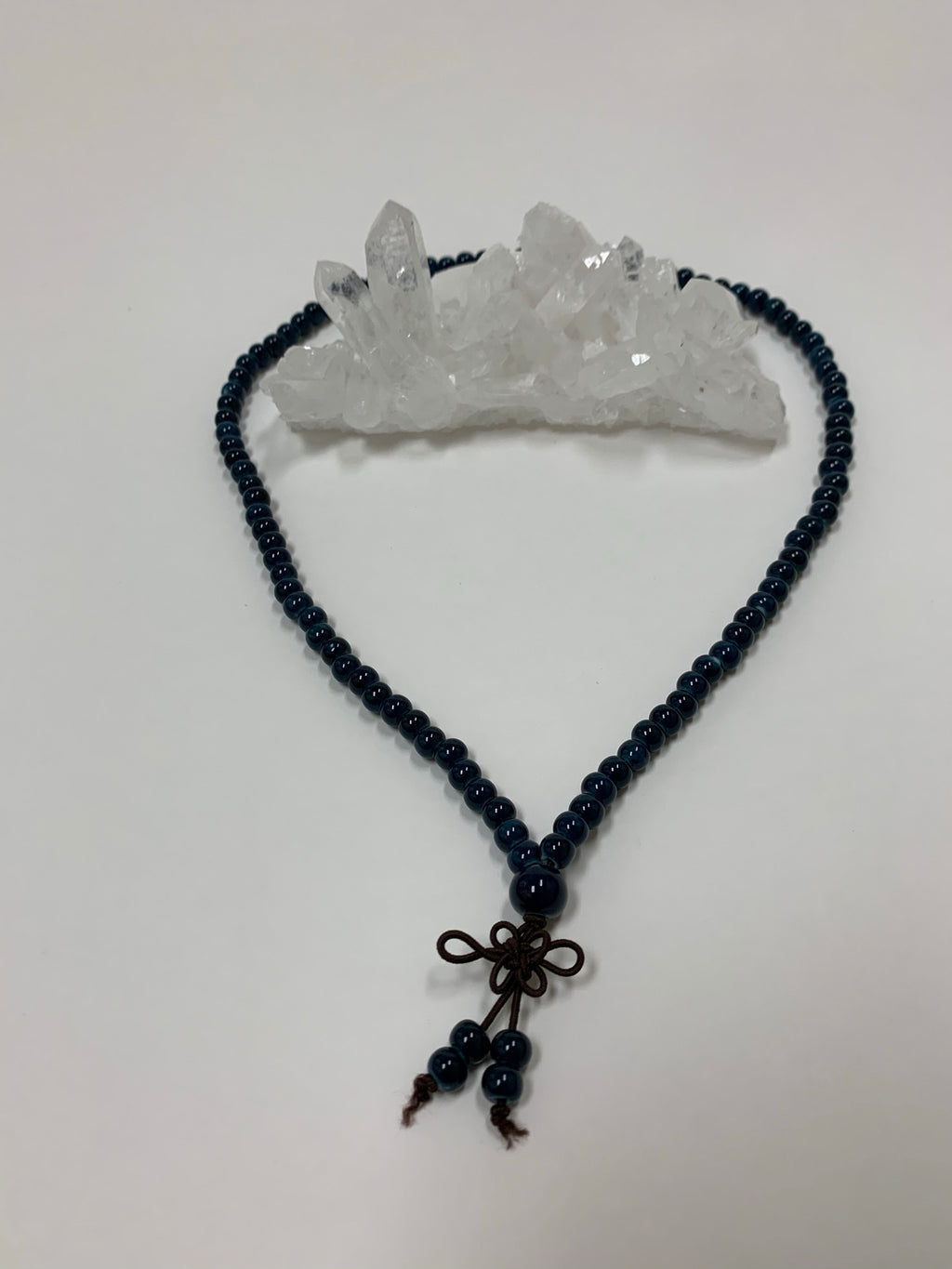 Prayer beads/mala necklace consists of 108 small, blue ceramic beads. Used to count 108 repetitions of a mantra, so the user can pay attention to the sounds, vibrations and meaning of the mantra being chanted. 