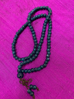 Load image into Gallery viewer, Close-up view. Prayer beads/mala necklace consists of 108 small, blue ceramic beads. Used to count 108 repetitions of a mantra, so the user can pay attention to the sounds, vibrations and meaning of the mantra being chanted.
