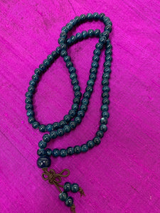 Close-up view. Prayer beads/mala necklace consists of 108 small, blue ceramic beads. Used to count 108 repetitions of a mantra, so the user can pay attention to the sounds, vibrations and meaning of the mantra being chanted.