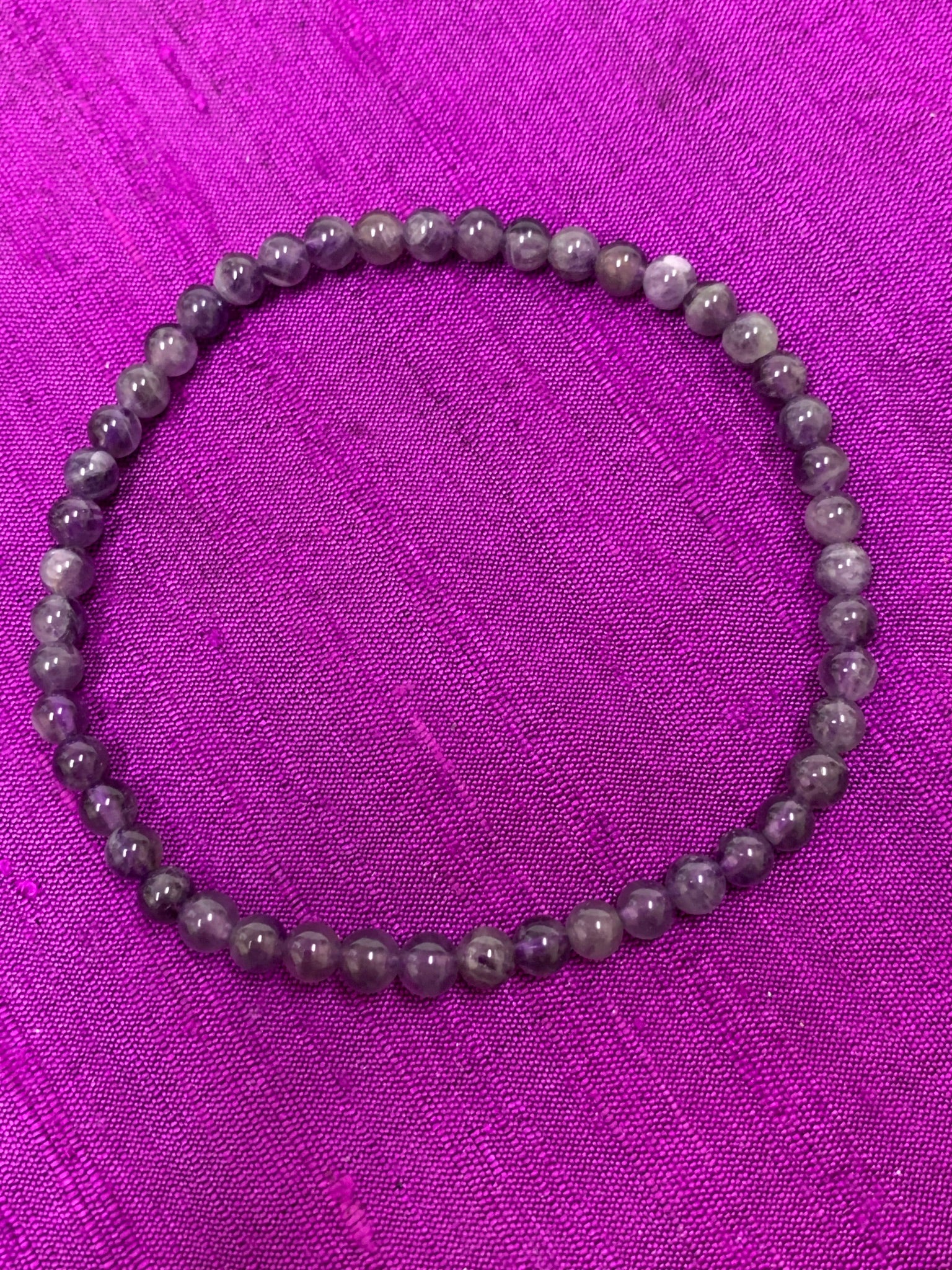 Close-up view. Petite amethyst 4mm power bracelet. Tiny and mighty, this bracelet puts the power of amethyst right around your wrist. Buy one or wear them and share them - they come in a variety of gemstone choices.